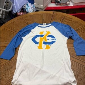 Charlie Hustle UMKC Blue and White Raglan Long Sleeve Tee with Yellow Graphic